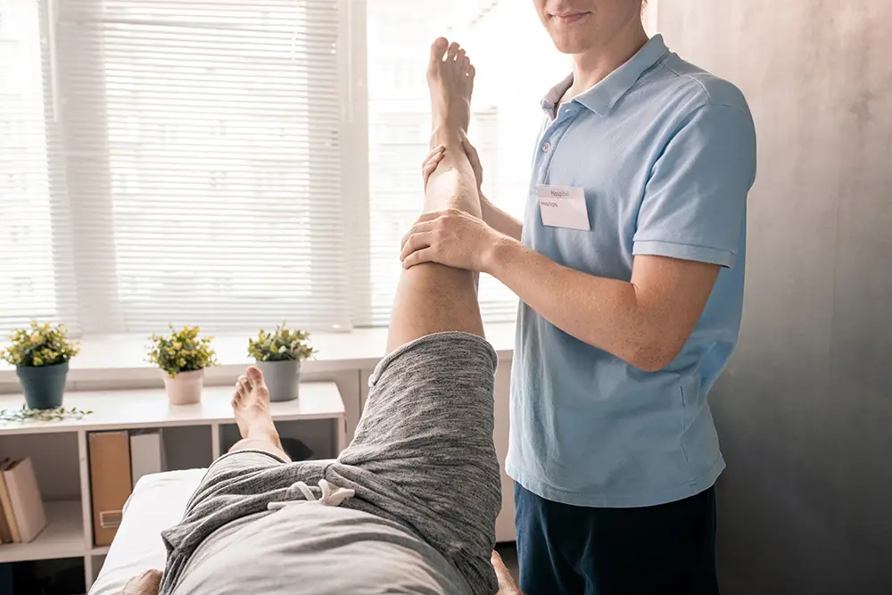 Top 7 instances a functional capacity evaluation can benefit you physiotherapist holding leg of patient while helpi 2021 09 24 03 23 55 utc top 7 instances a functional capacity evaluation can benefit you | excel rehab & sports